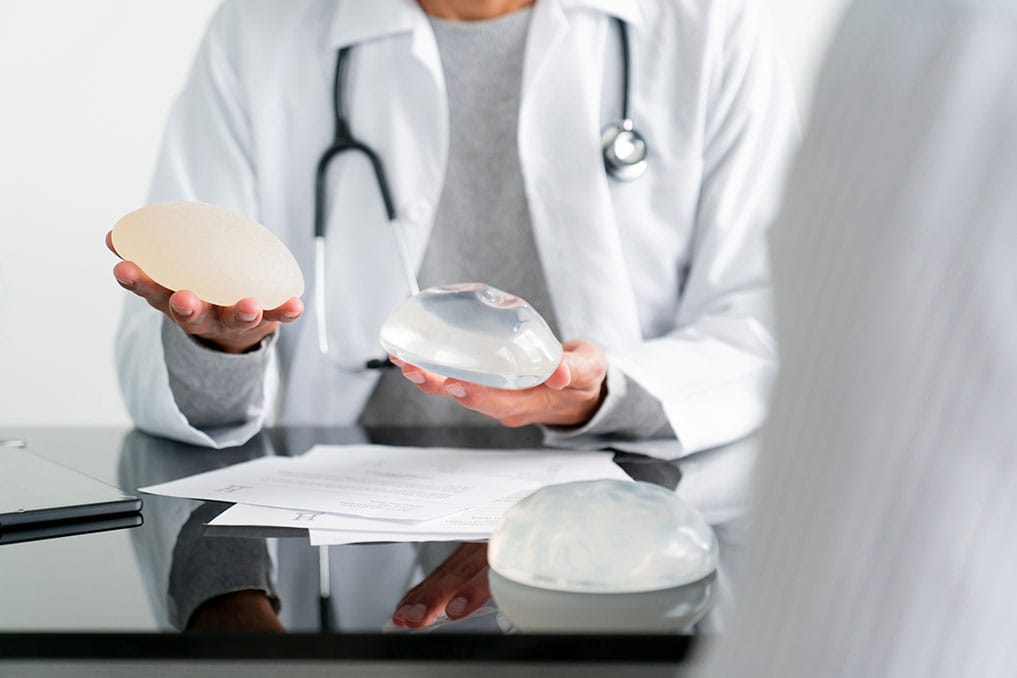 doctor showing breast implant options to a patient in Marietta